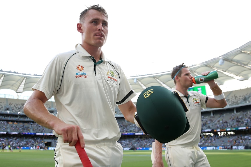 Two Australian male batters walk off the field in Perth after batting against New Zealand.