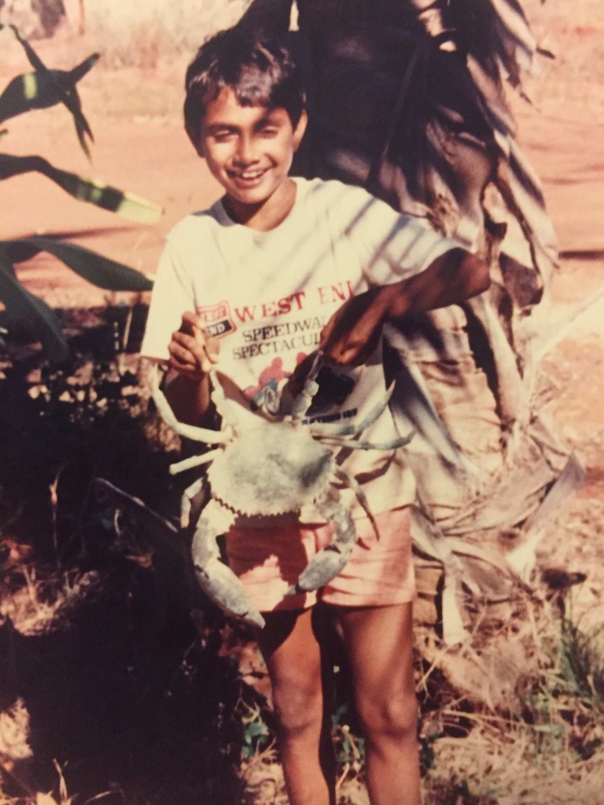 A young Justin Walker holds a crab