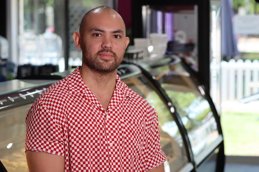 A man wearing a red and white checked shirt. 