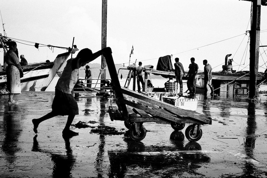 A child pushes a crate along the waterfront in Malaysia's Sabah state.