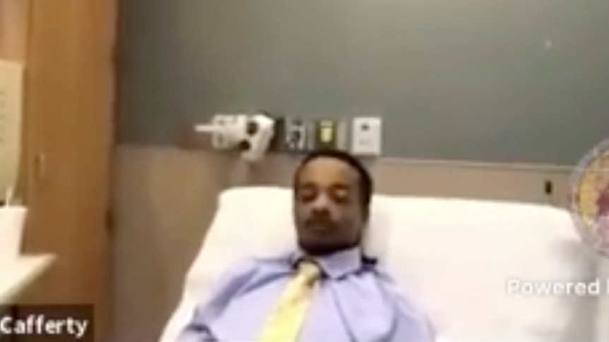 Jacob Blake wears a shirt and tie while he lies in a hospital bed and appears on the Kenosha County Court's video link.