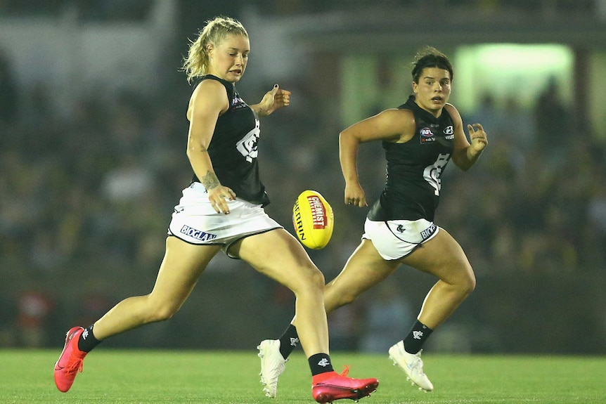 Tayla Harris watches the ball onto her boot as Maddy Prespakis runs behind her.