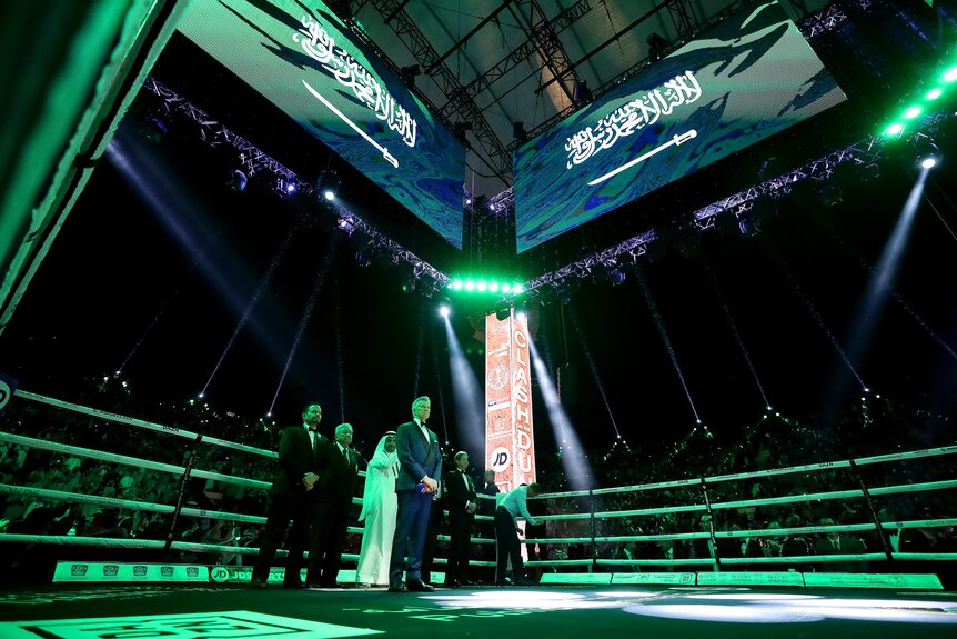 Un ring de boxe en Arabie Saoudite illuminé en vert avec le drapeau saoudien