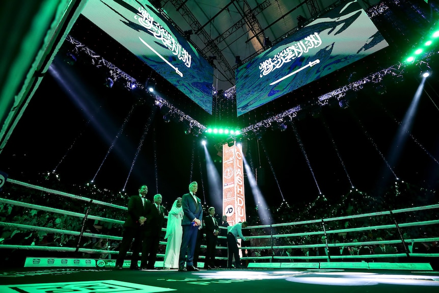 A boxing ring in Saudi Arabia lit up in green with the Saudi flag