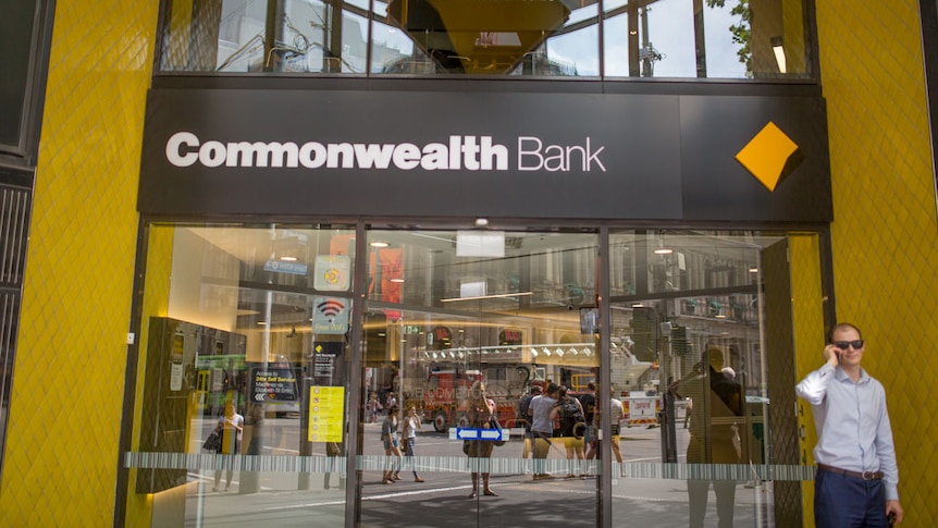 A man talks on the phone outside a Commonwealth Bank branch in Melbourne's CBD.