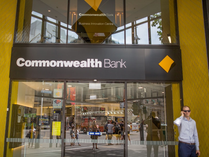 A man talks on the phone outside a Commonwealth Bank branch in Melbourne's CBD