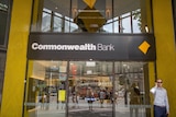 A man talks on the phone outside a Commonwealth Bank branch in Melbourne's CBD.