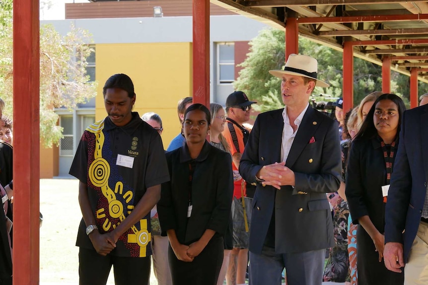 Students Danielle Campbell, Mishai Wollogorang walk and talk with Prince Edward outside their school in Alice Springs.