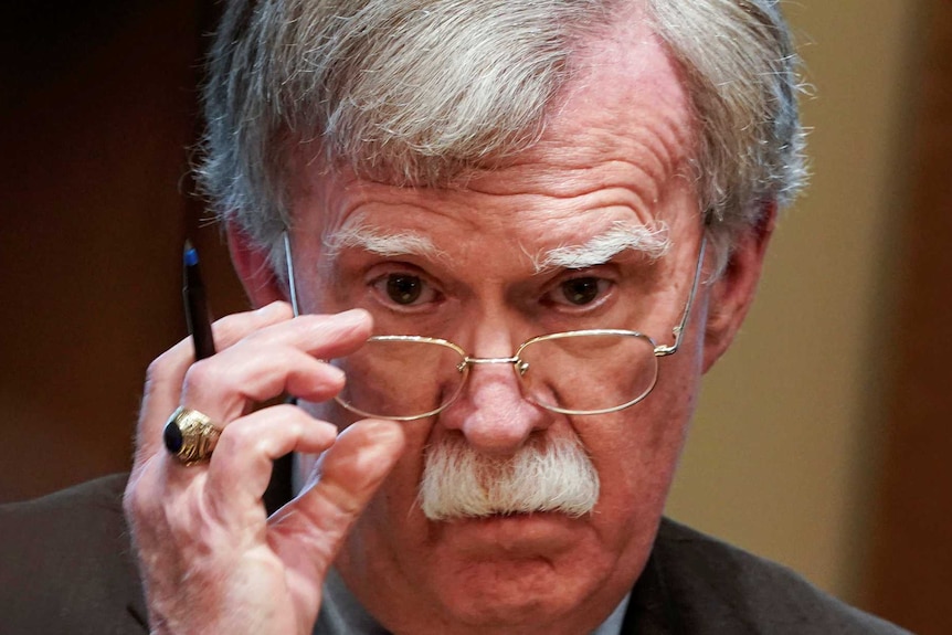 Former White House National Security Advisor John Bolton adjusts his glasses