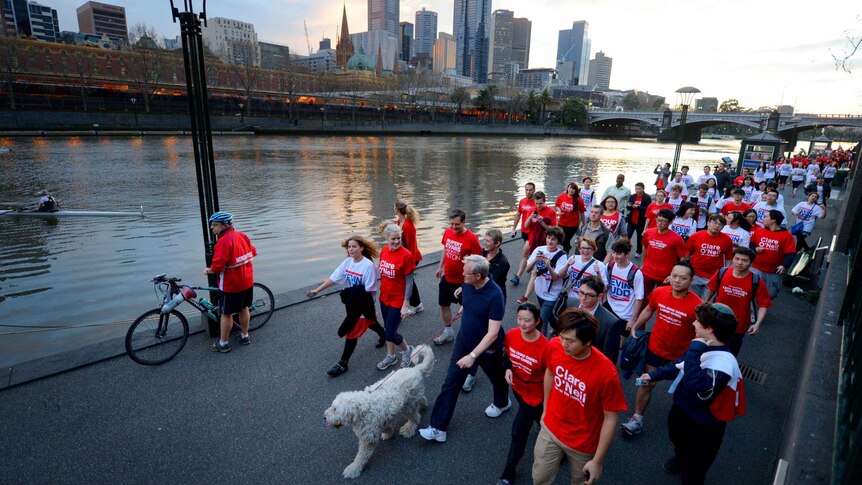 Kevin Rudd walks with young volunteers and supporters beside the Yarra River.