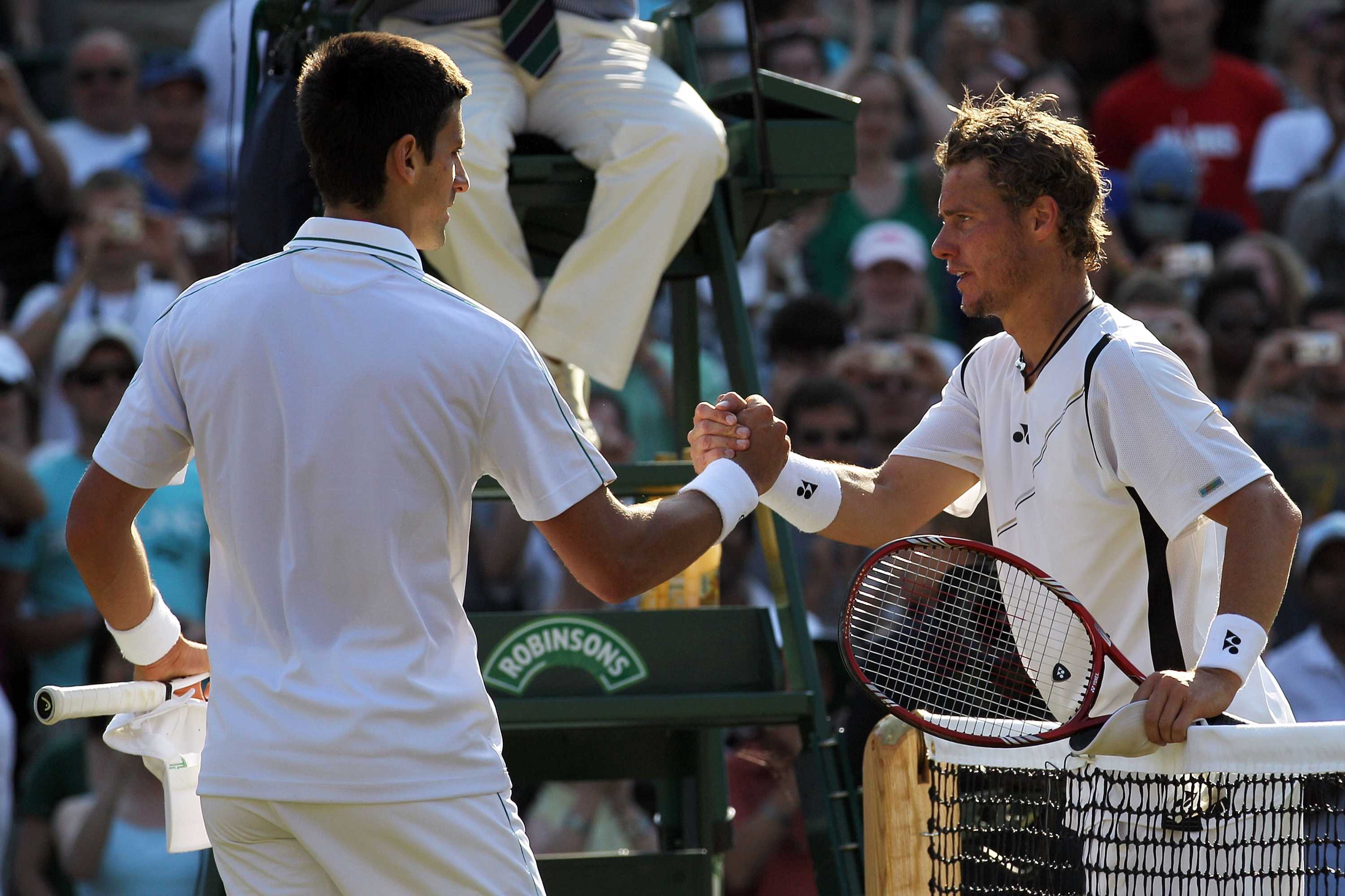 Novak Djokovic shakes hands with Lleyton Hewitt after winning their match at Wimbledon in June 2010.