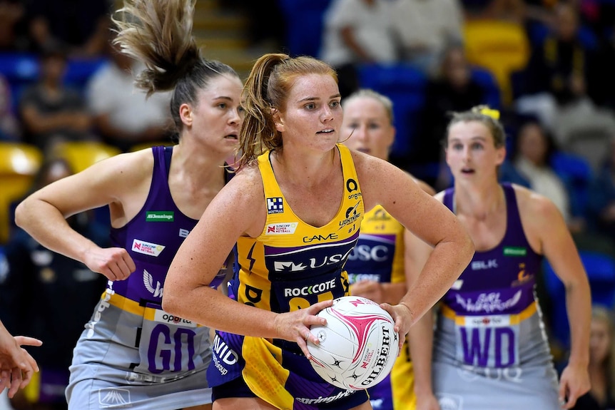 A Sunshine Coast Lightning Super Netball player prepares to pass the ball against Queensland Firebirds.