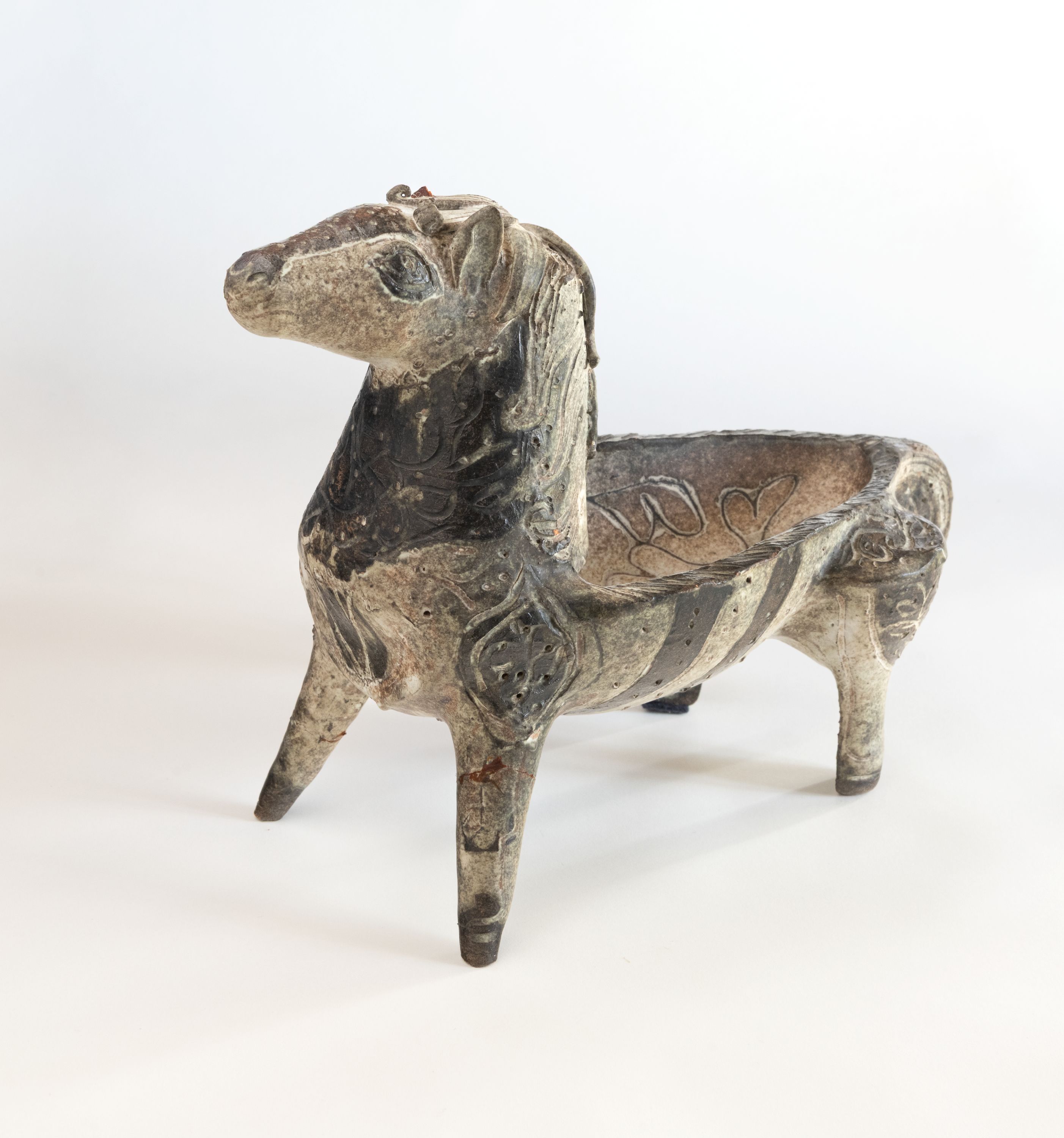 Cerâmica em forma de cavalo de meados dos anos 60, feita para segurar um prato. Está esculpido com imagens.