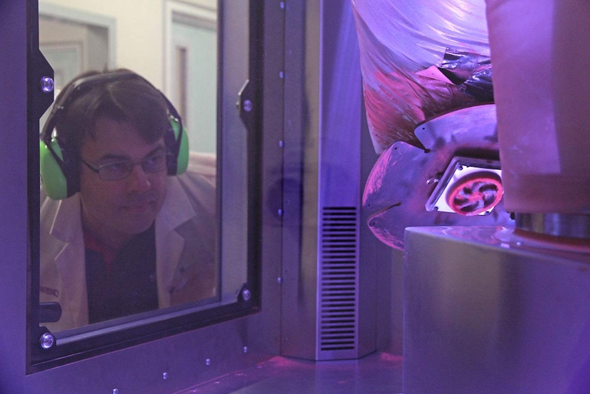 Steven Camilleri watches the copper flywheel being printed by the SPEE3D printer.