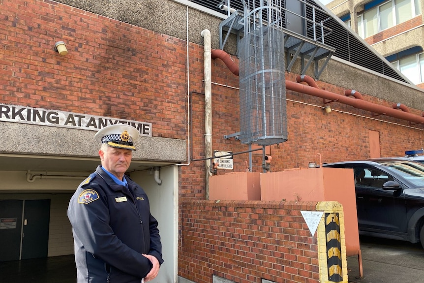 Commander Brett Smith stands in front of smoke damage to Launceston Police Station