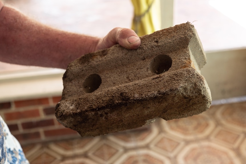 A brick in a person's hand