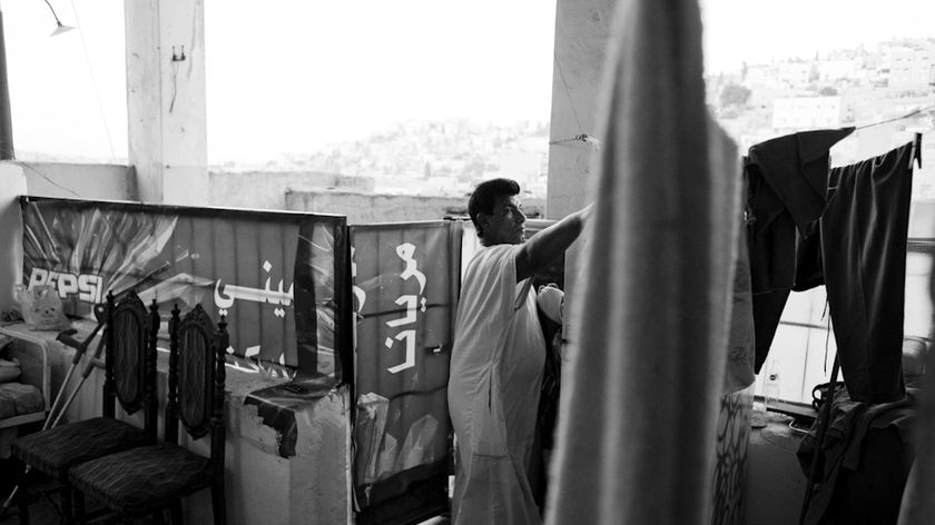 Nadim, an Iraqi refugee from Baghdad, hangs washing in his home in Amman, Jordan.