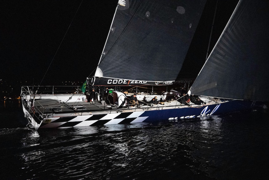 A large yacht sails at night.