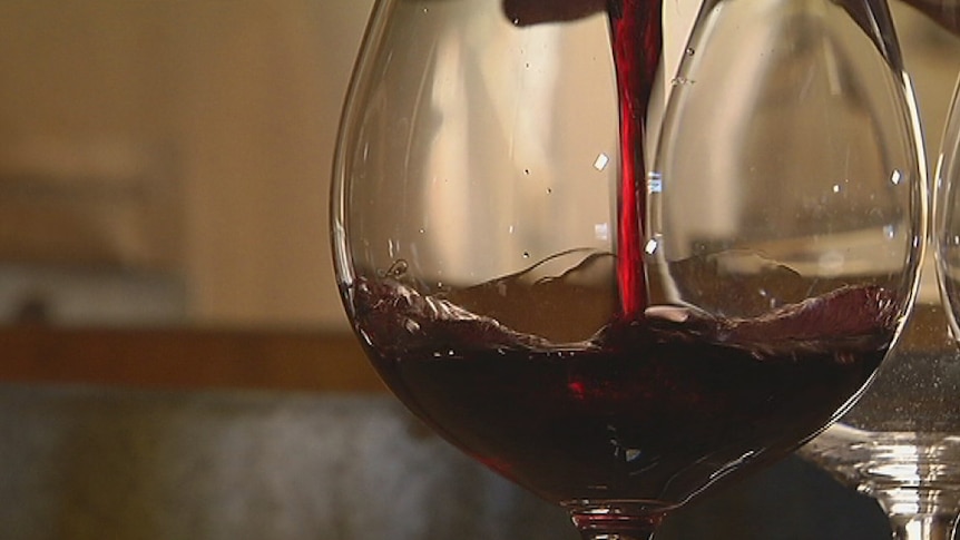 Red wine being poured into a glass.