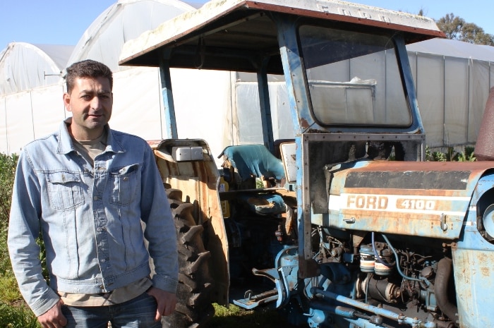 A man standing beside a tractor