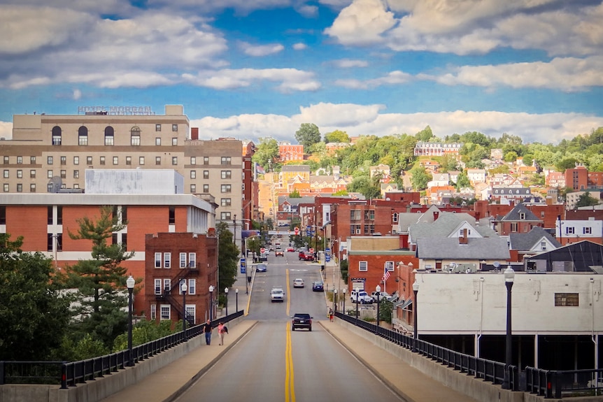 A road running through a small, historic US town under a blue sky
