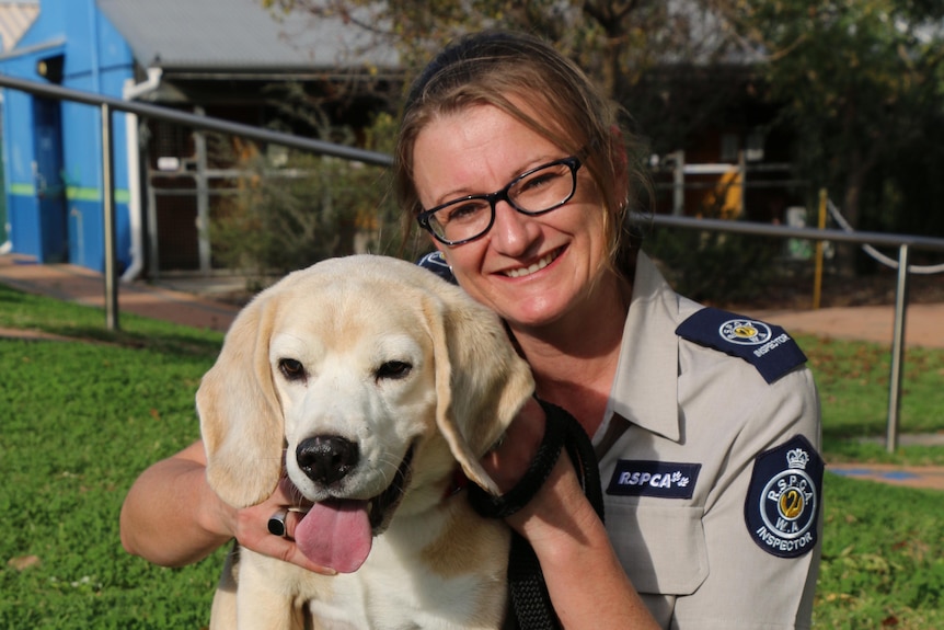 a woman holds a dog