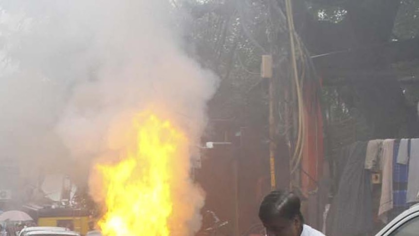 Tension rises: A car burns near the scene of the shooting attack in Delhi's Old City