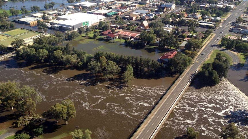 The swollen Lachlan River rushes under the bridge in Forbes