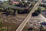 The swollen Lachlan River rushes under the bridge in Forbes