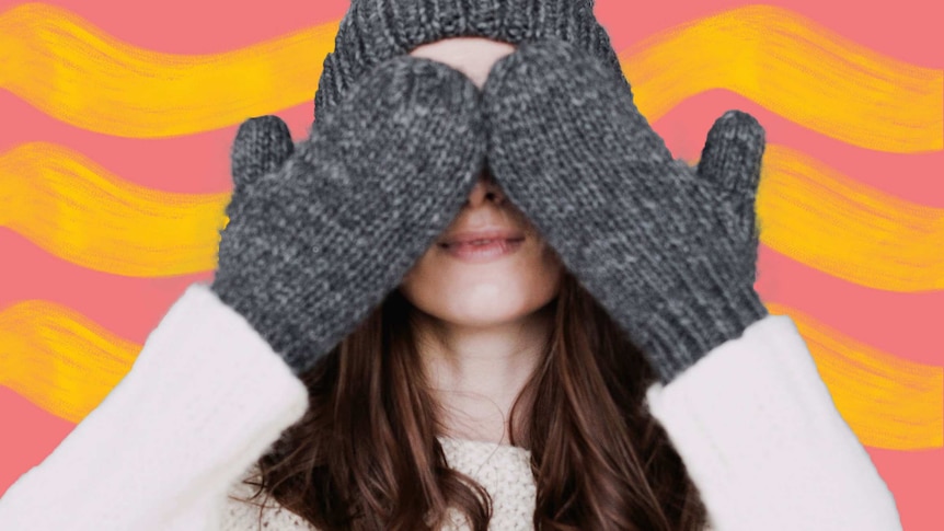 Woman in winter clothes covering her eyes for a story about how to keep warm in winter with heating