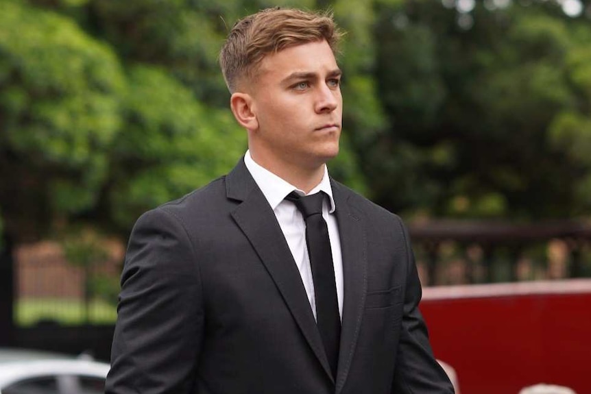 Two men wearing ties walk towards the camera.