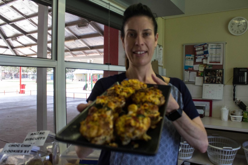 Leora Muller holds up a plate of her vegetable quiches to the camera.
