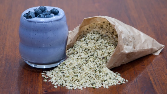 Smoothie and brown paper bag of hemp seeds.