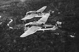 A black and white photo of planes flying over jungle.