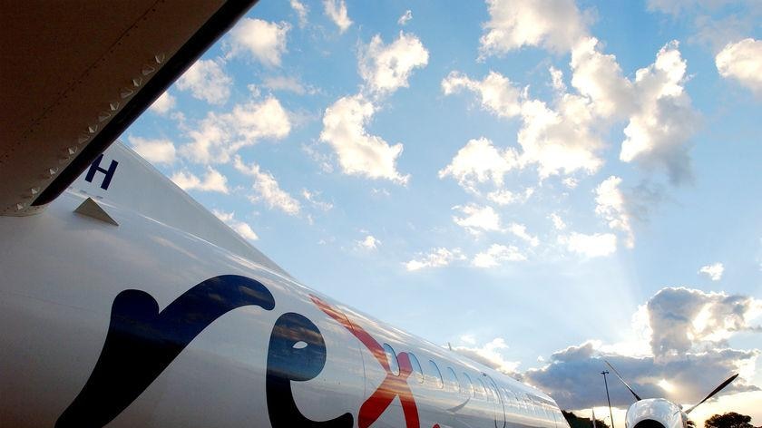 The fuselage of a white, propeller-driven aeroplane. It reads "Rex".