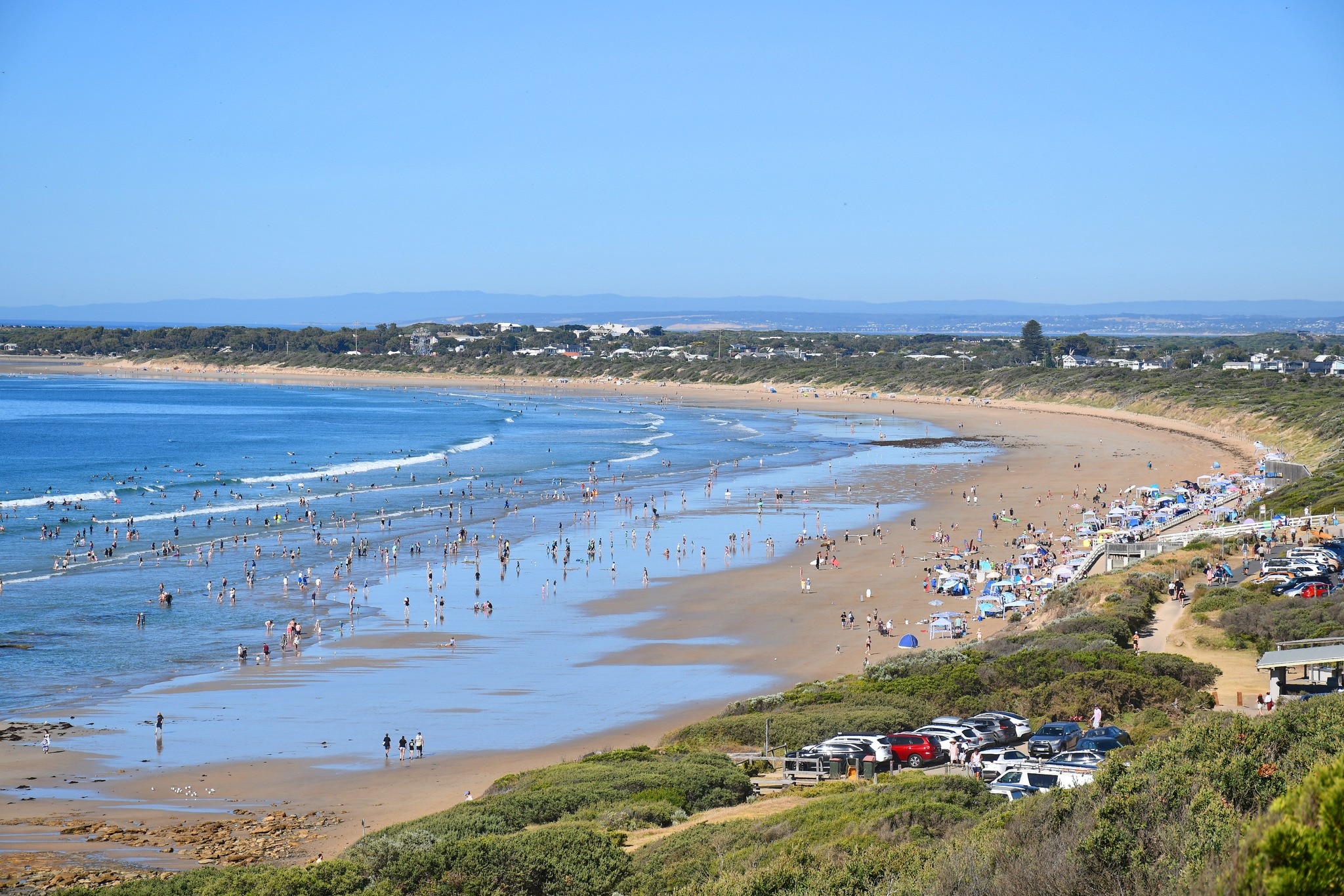 Vista de uma praia de cima com pessoas andando