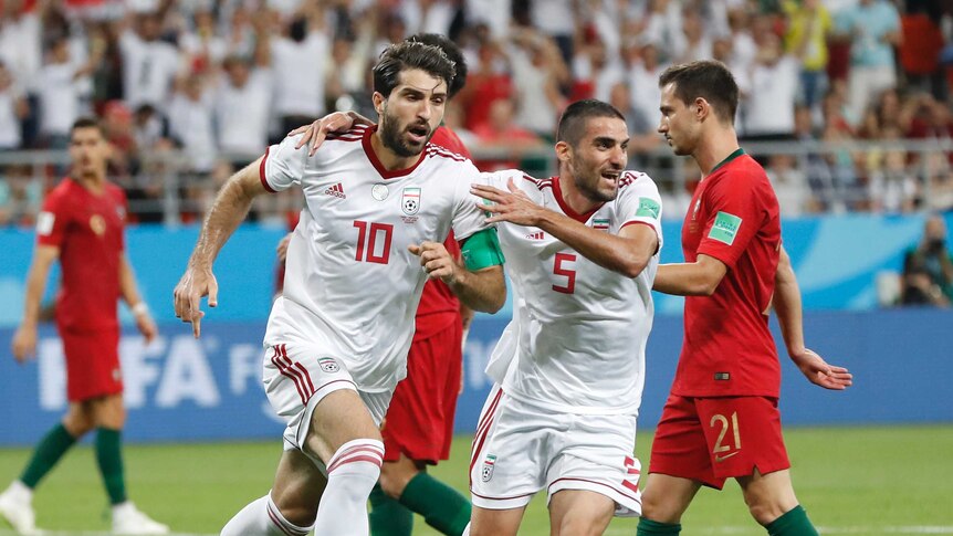 Iran's players celebrate scoring last minute goal agaianst Portugal