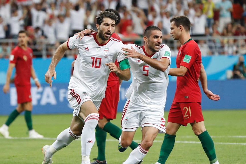 Iran's players celebrate scoring last minute goal agaianst Portugal