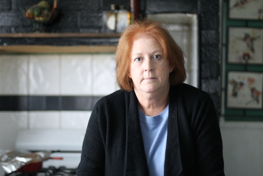 portrait shot of Andrea in front of tiles in kitchen