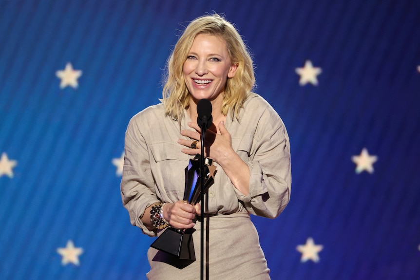 Cate smiles on stage with her award.