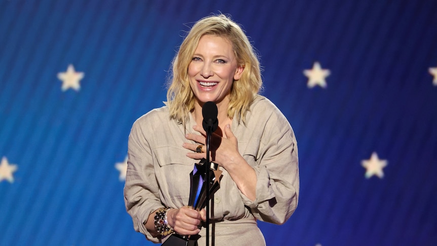 Cate smiles on stage with her award.
