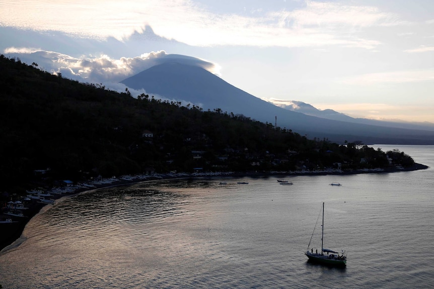 The sun sets behind Mount Agung in Bali.