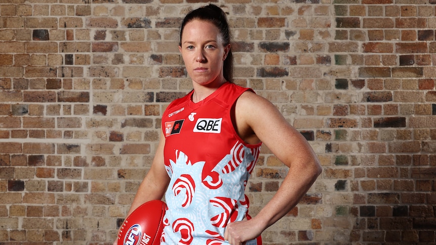 Brooke Lochland poses with a ball in the Sydney Swans guernsey