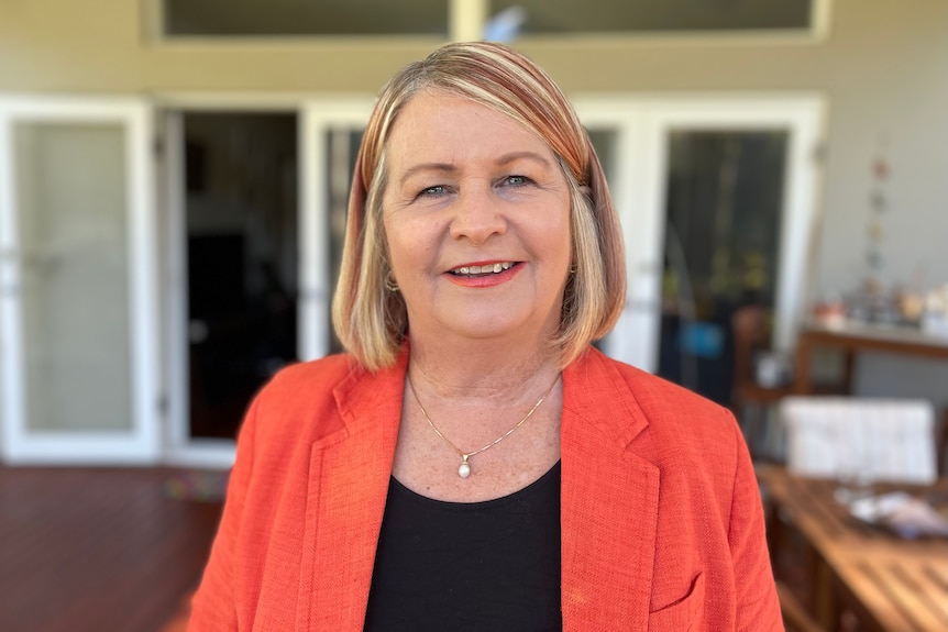 Lana Glogowski wearing a red blazer and black shirt, smiling at the camera.