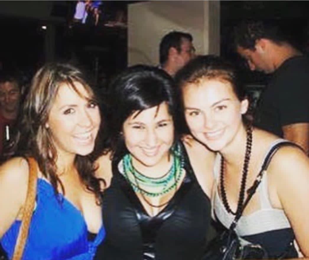 Three young women stand side-by-side, smiling.