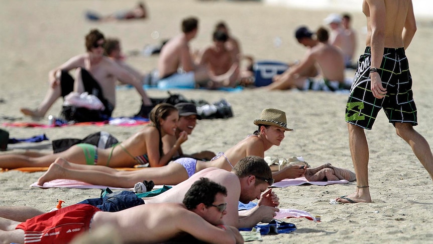 People sunbake on the beach