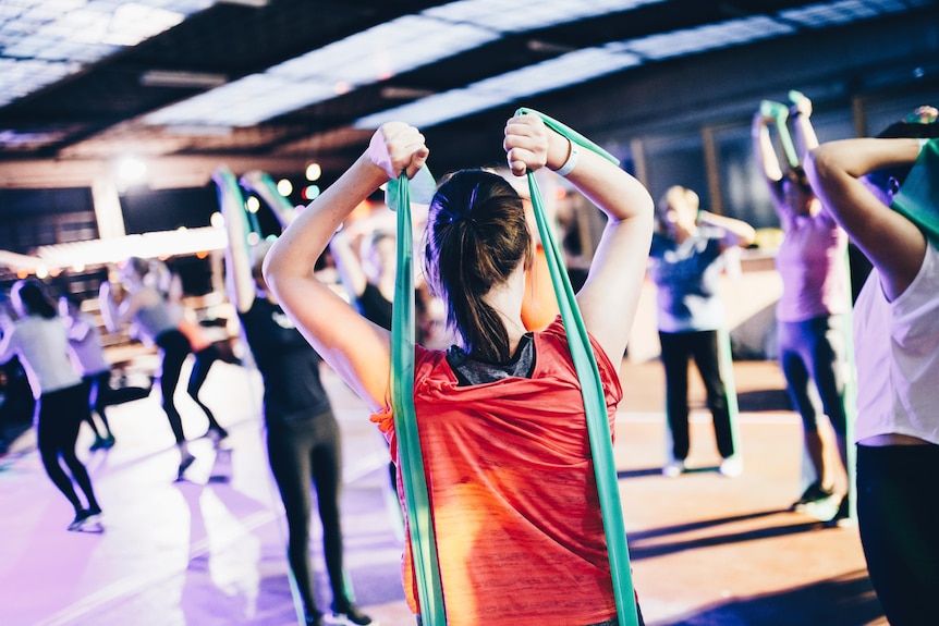 A sports class filled with people using resistance bands 