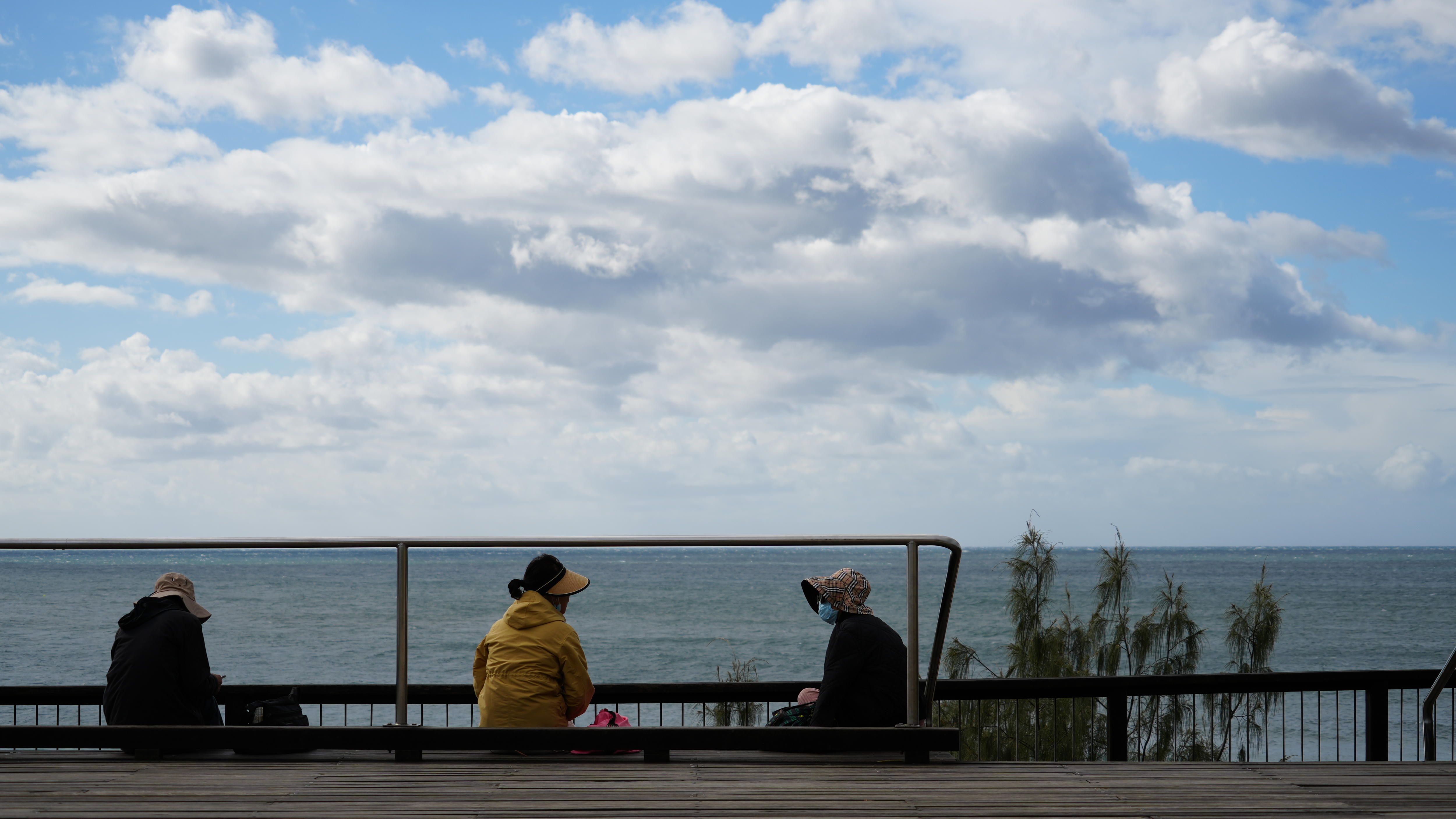 Women at beach wearing jumpers