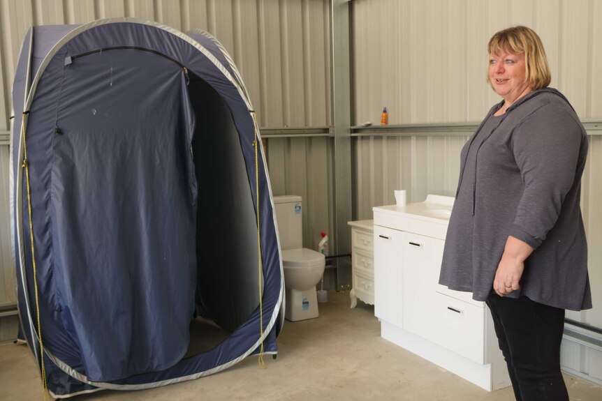 A toilet and a tent next to one another in a shed.