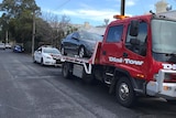 A car on the back of a tow truck after being seized by police.